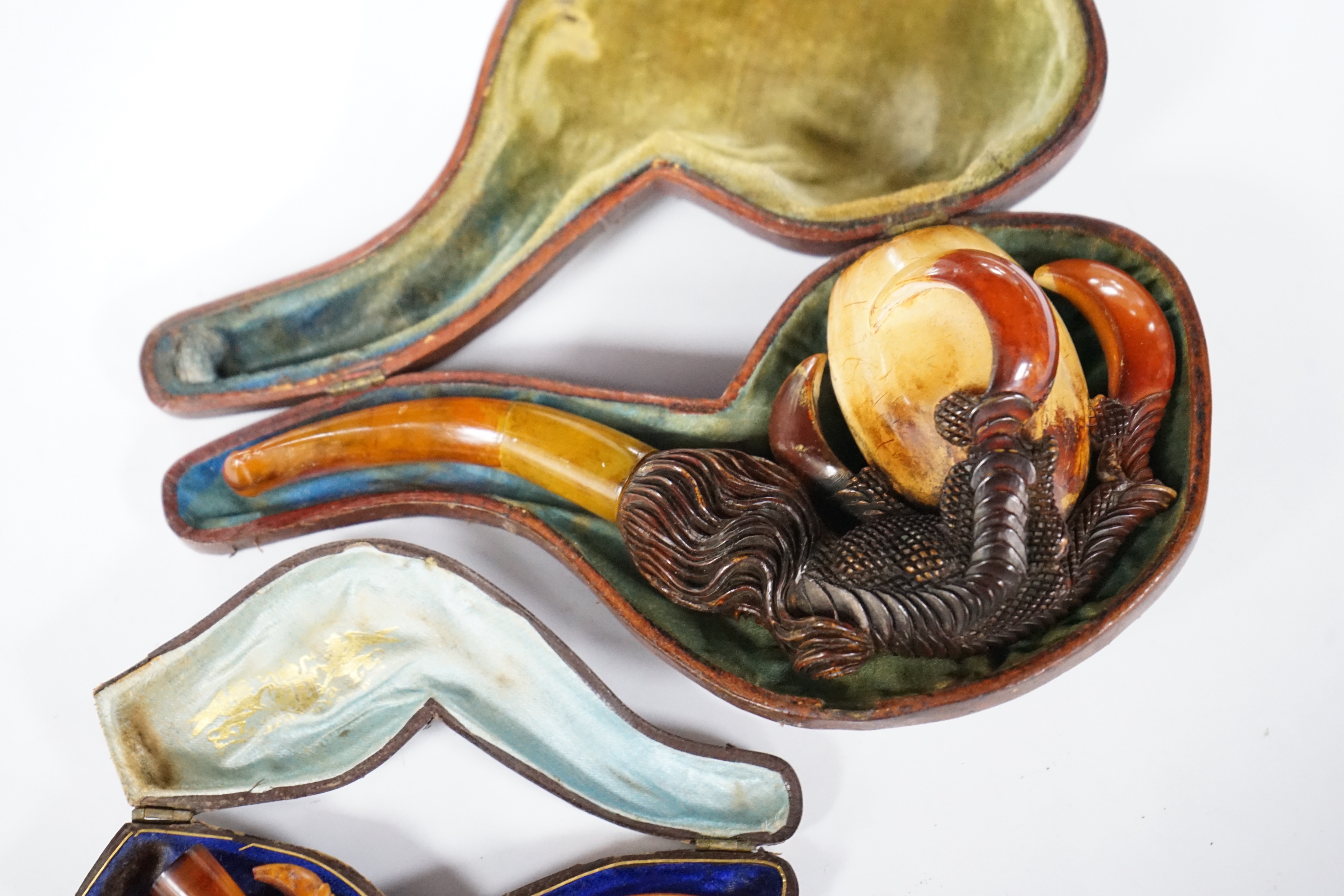 Two novelty Meerschaum pipes both with dragon claw talon pipe bowls and amber mouthpieces, largest 17cm long